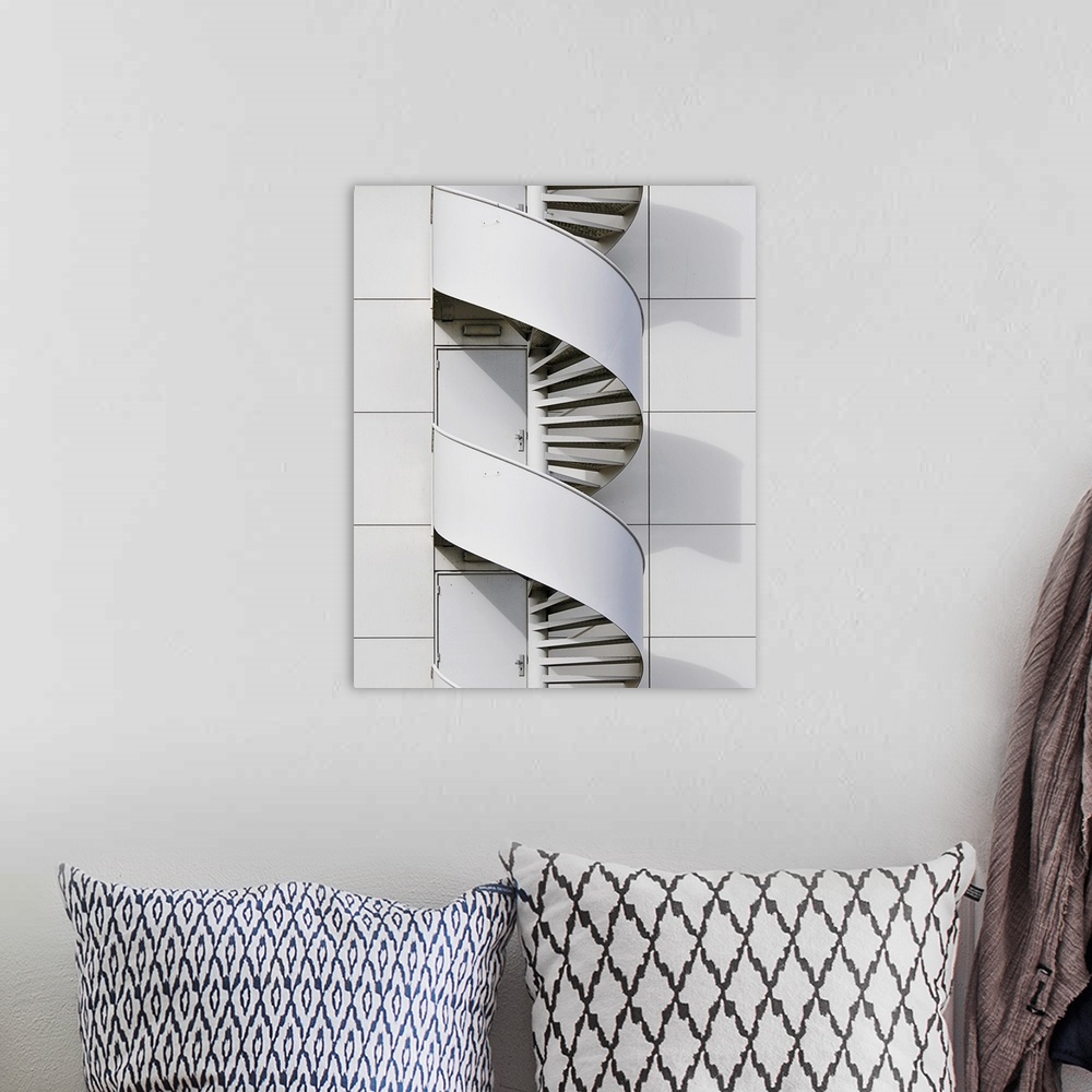 A bohemian room featuring Geometric photograph of a swirly fire escape running along the side of a white building.