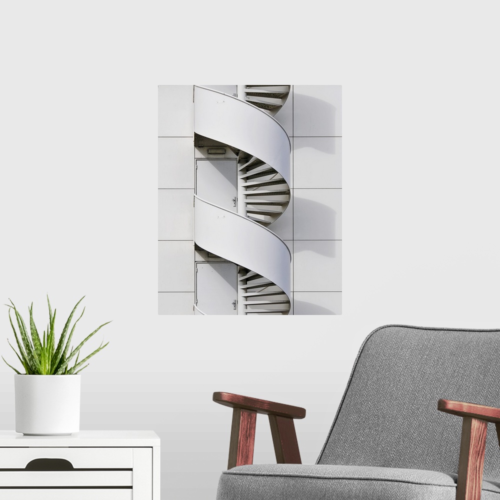 A modern room featuring Geometric photograph of a swirly fire escape running along the side of a white building.