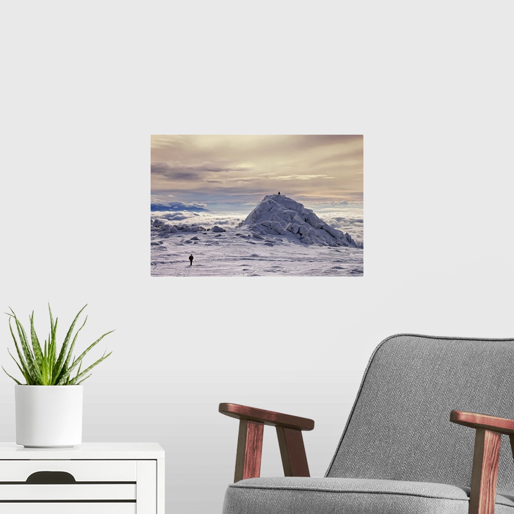 A modern room featuring A figure walks across a snowscape on a mountain top, with another figure on a hill in the distanc...