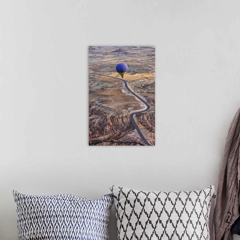 A bohemian room featuring A blue hot air balloon flying high above a rugged and arid looking landscape.