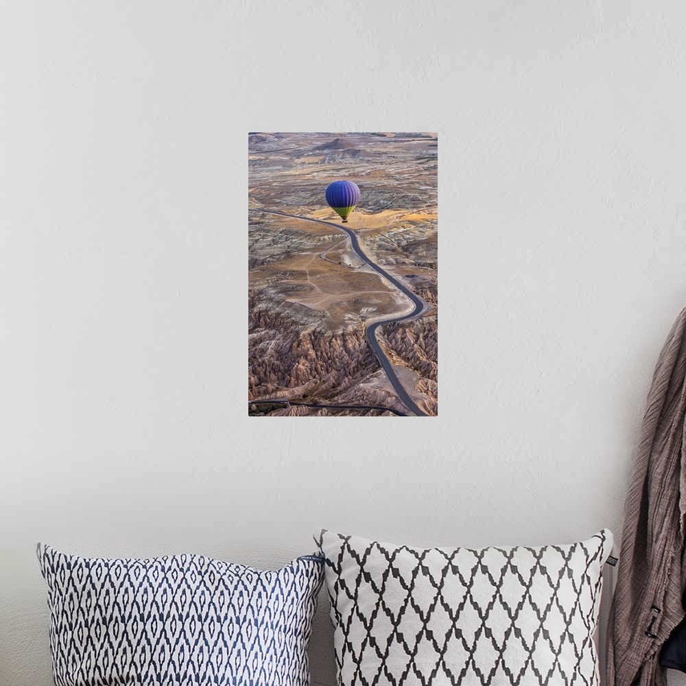 A bohemian room featuring A blue hot air balloon flying high above a rugged and arid looking landscape.