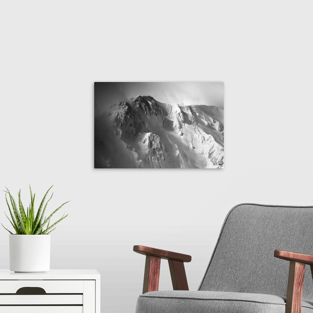 A modern room featuring Black and white image of the Tatras Mountains with an immense amount of snow, with a tiny figure ...