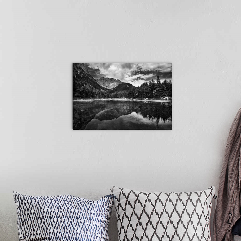 A bohemian room featuring A black and white photograph of a wilderness scene with a mountain range and forest reflecting in...