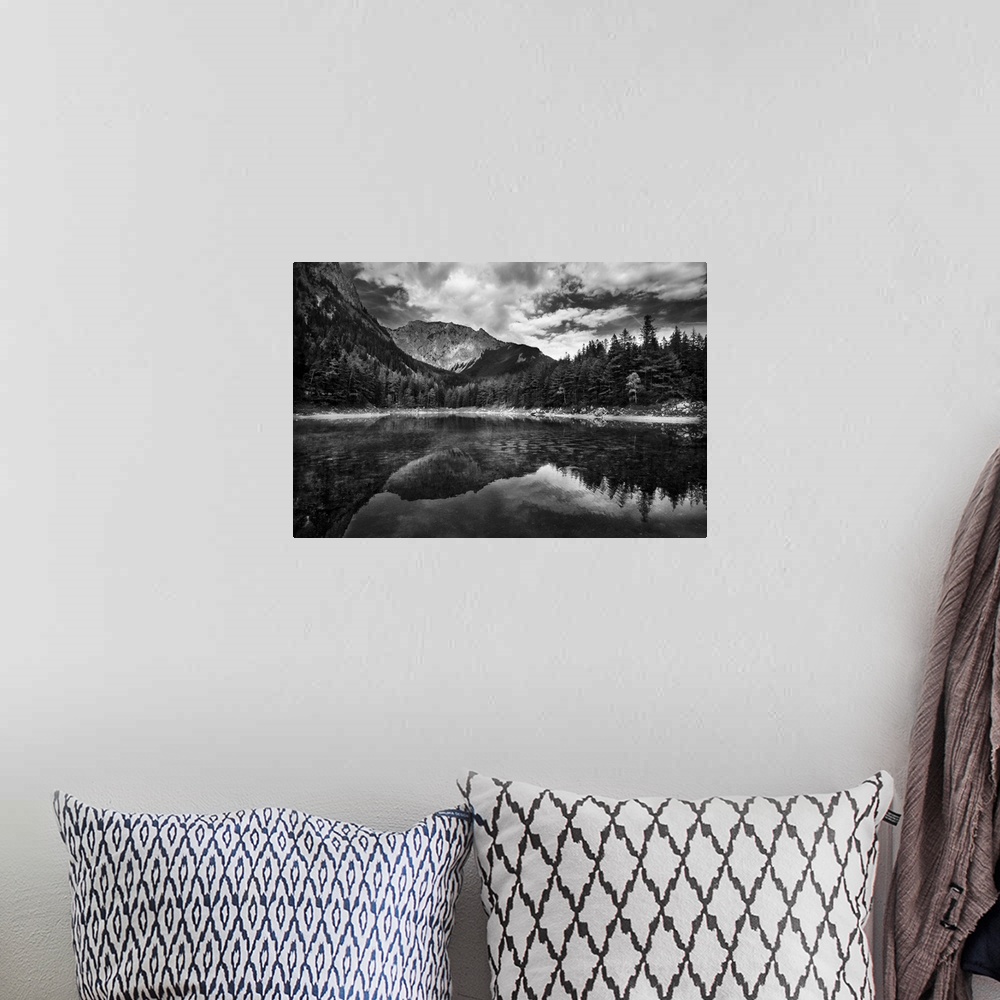 A bohemian room featuring A black and white photograph of a wilderness scene with a mountain range and forest reflecting in...