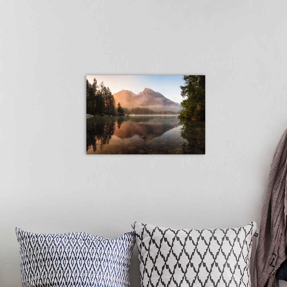 A bohemian room featuring Reflective landscape photograph on a lake with trees and mountains in the background at sunrise.