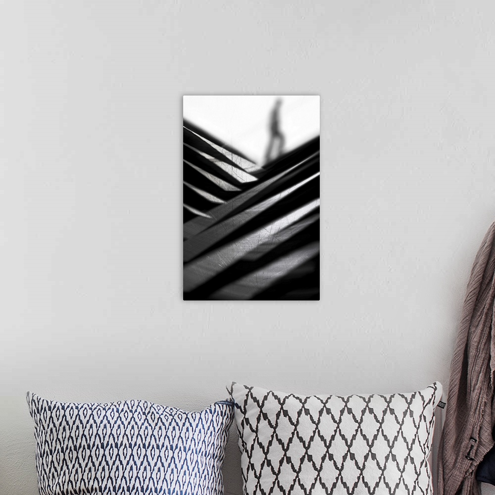 A bohemian room featuring Abstract black and white image of criss-crossing metal, with a blurry figure in the distance.