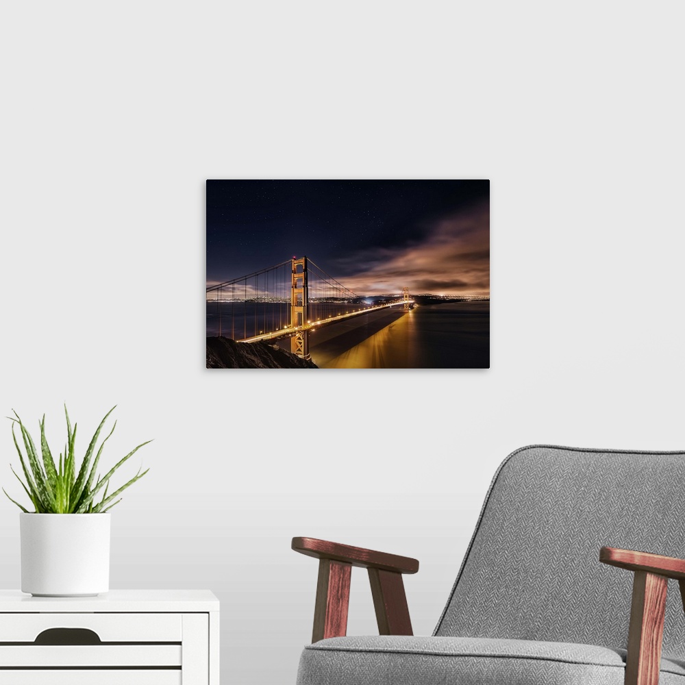 A modern room featuring Photograph of the Golden Gate Bridge lit up at night.