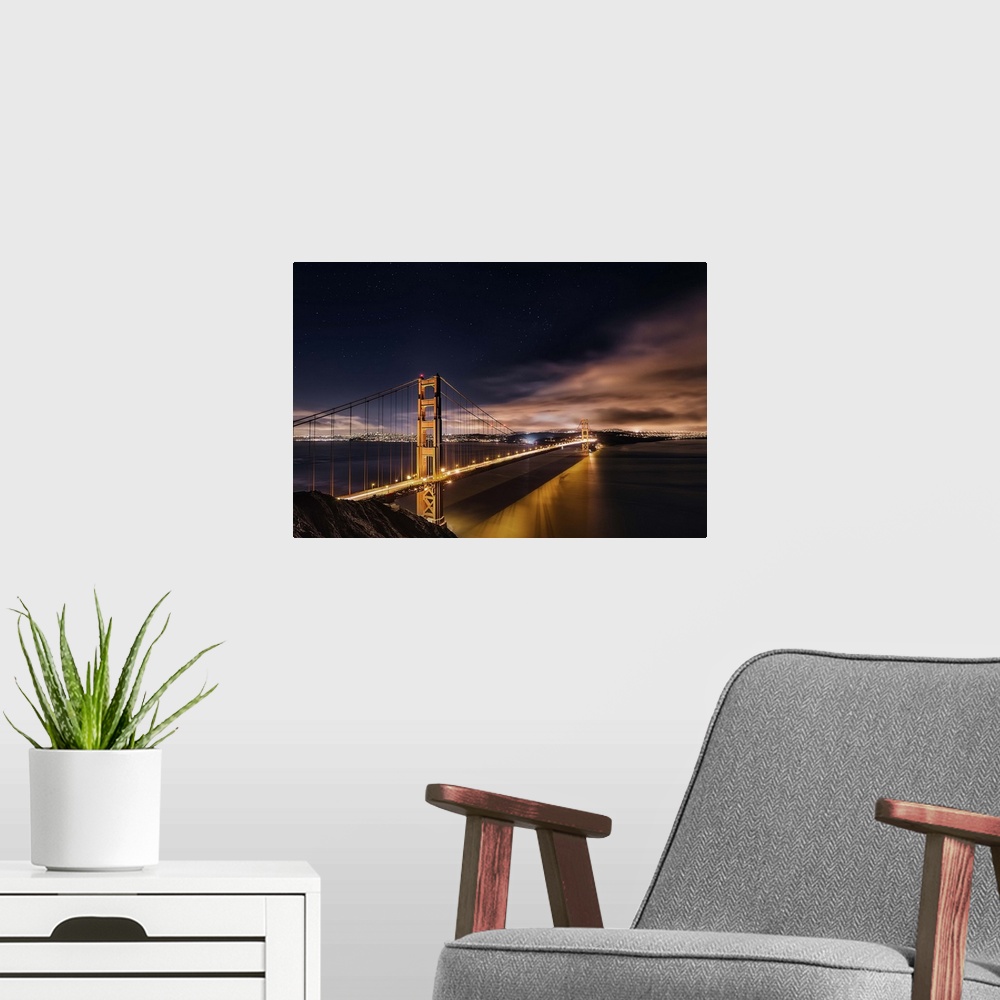 A modern room featuring Photograph of the Golden Gate Bridge lit up at night.