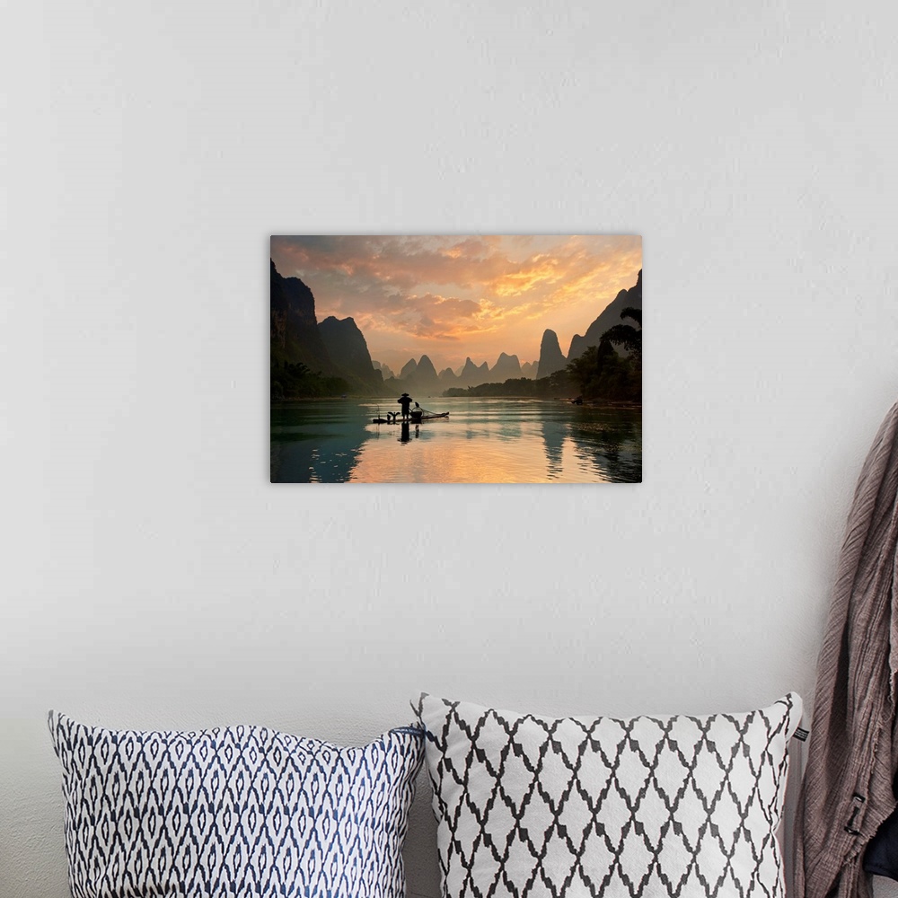 A bohemian room featuring A fisherman and his cormorants on a boat in the Li River at dawn, China.