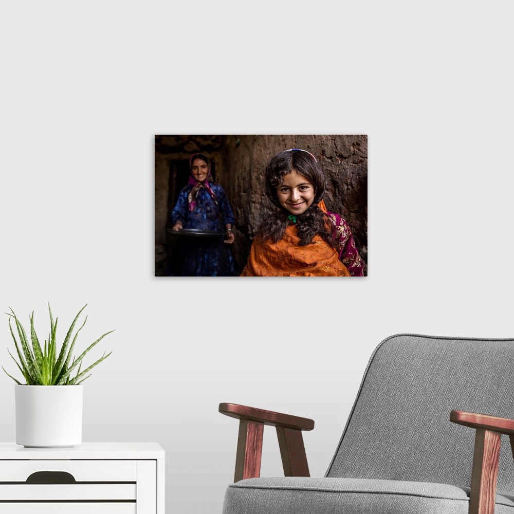 A modern room featuring A smiling young girl with her mother standing behind her, Iran.