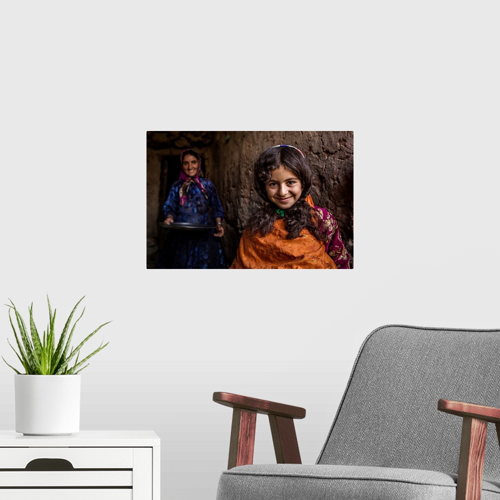 A modern room featuring A smiling young girl with her mother standing behind her, Iran.