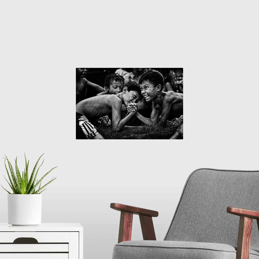 A modern room featuring A black and white photograph of children arm wrestling with other gathered around them.