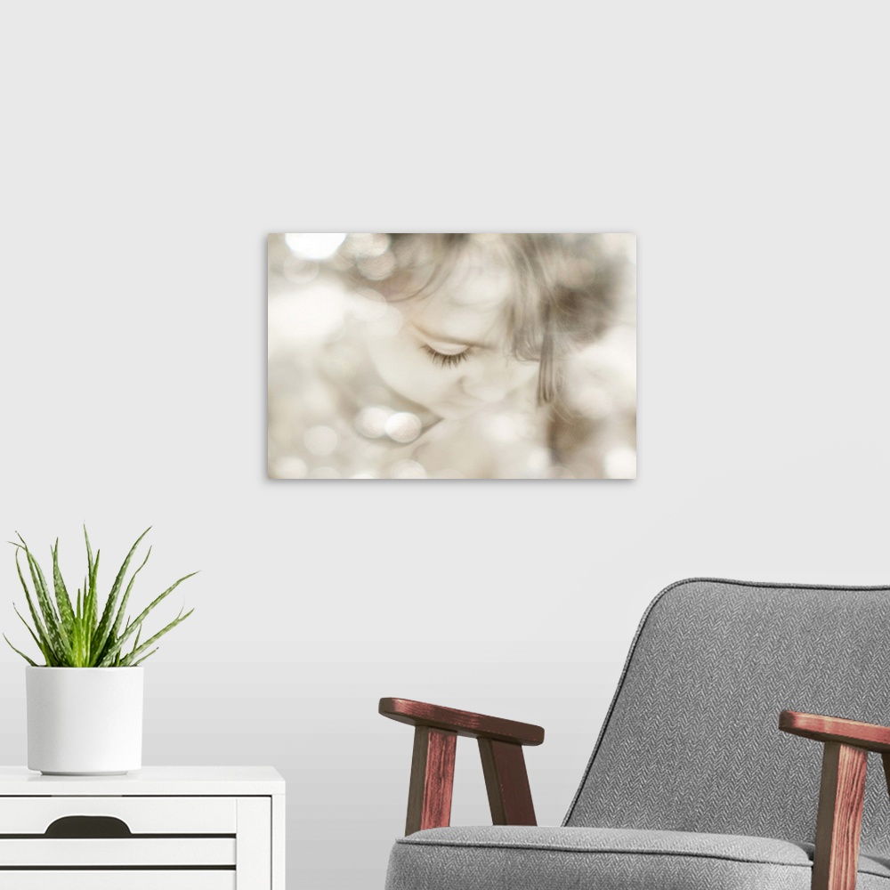 A modern room featuring The face of a little girl looking down, with bokeh highlights.