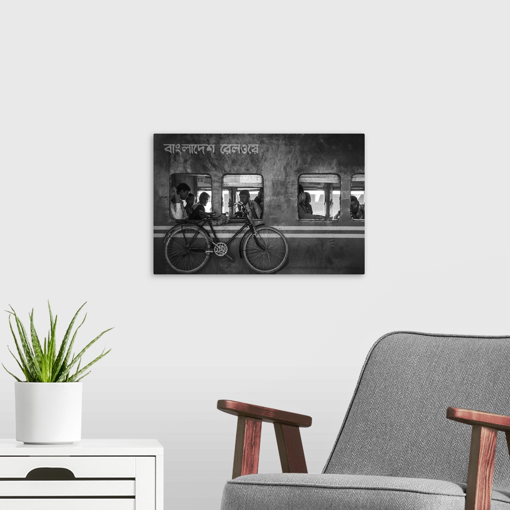 A modern room featuring A train with people heading home and a bike hanging from the side, Bangladesh.