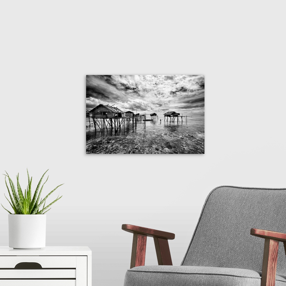 A modern room featuring Black and white image of a group of houses on stilts in the ocean, Sabah, Malaysia.