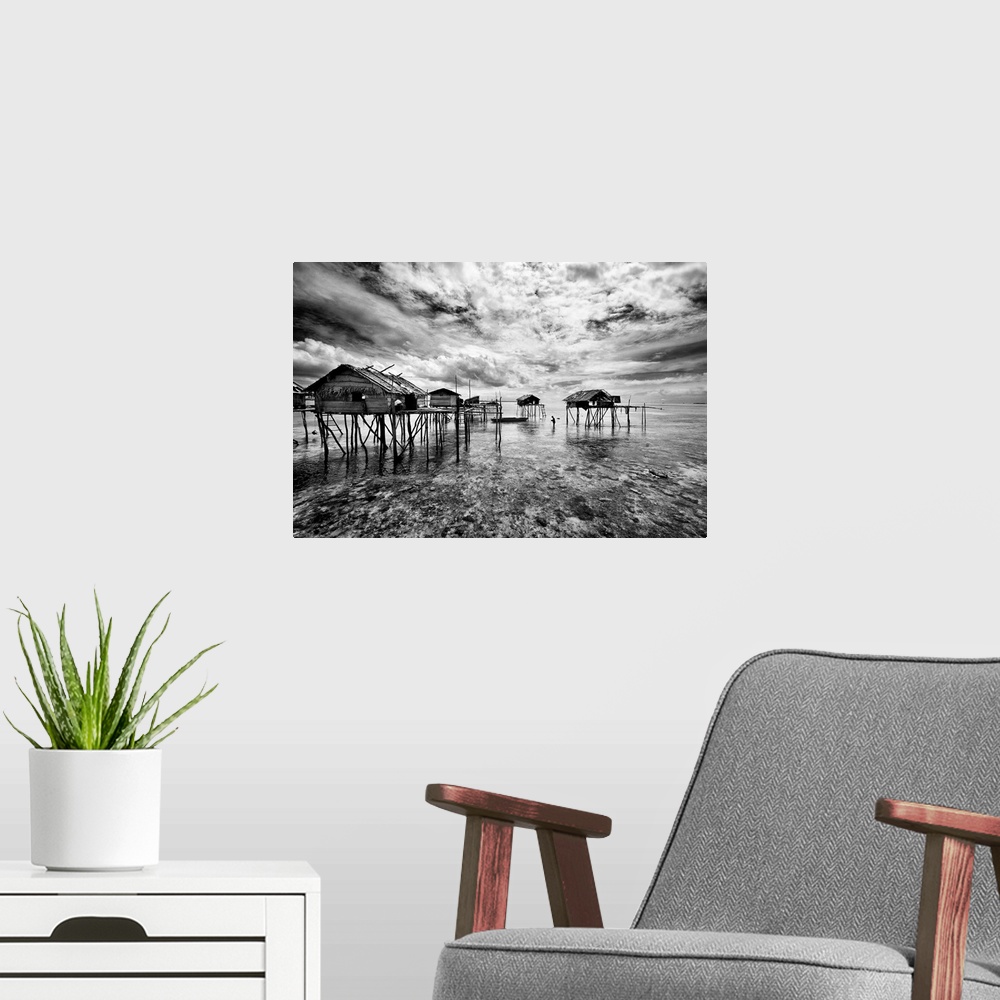 A modern room featuring Black and white image of a group of houses on stilts in the ocean, Sabah, Malaysia.
