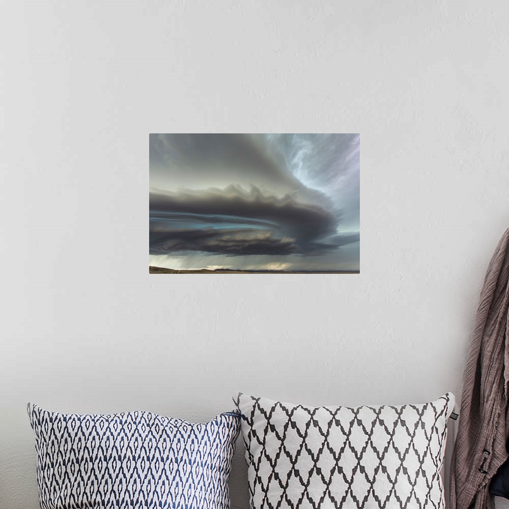 A bohemian room featuring Large menacing storm clouds rolling over a countryside landscape.