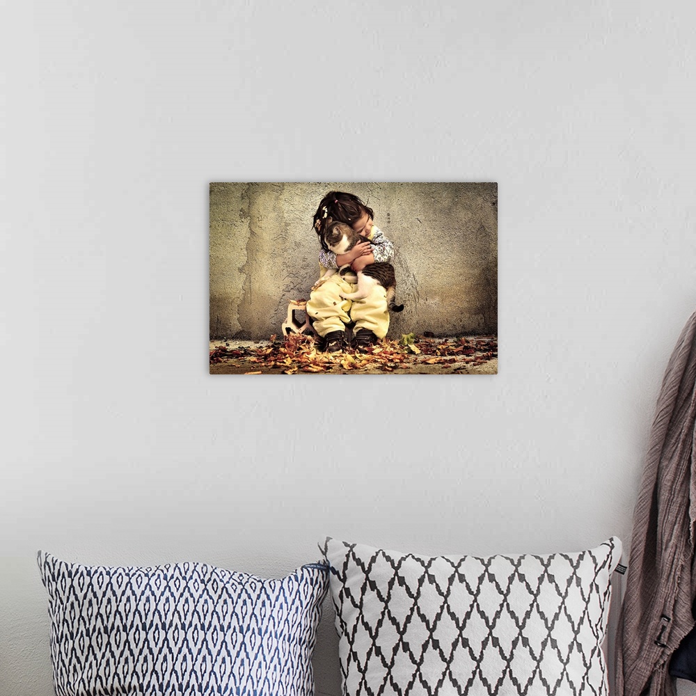 A bohemian room featuring A portrait of a little girl sitting against a wall and holding a cat in a loving embrace.