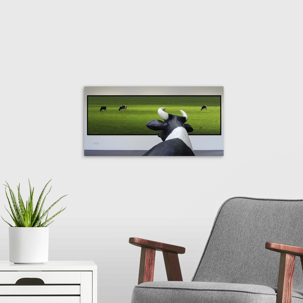 A modern room featuring Conceptual image of a cow looking at a framed photo of other cows in a green field.