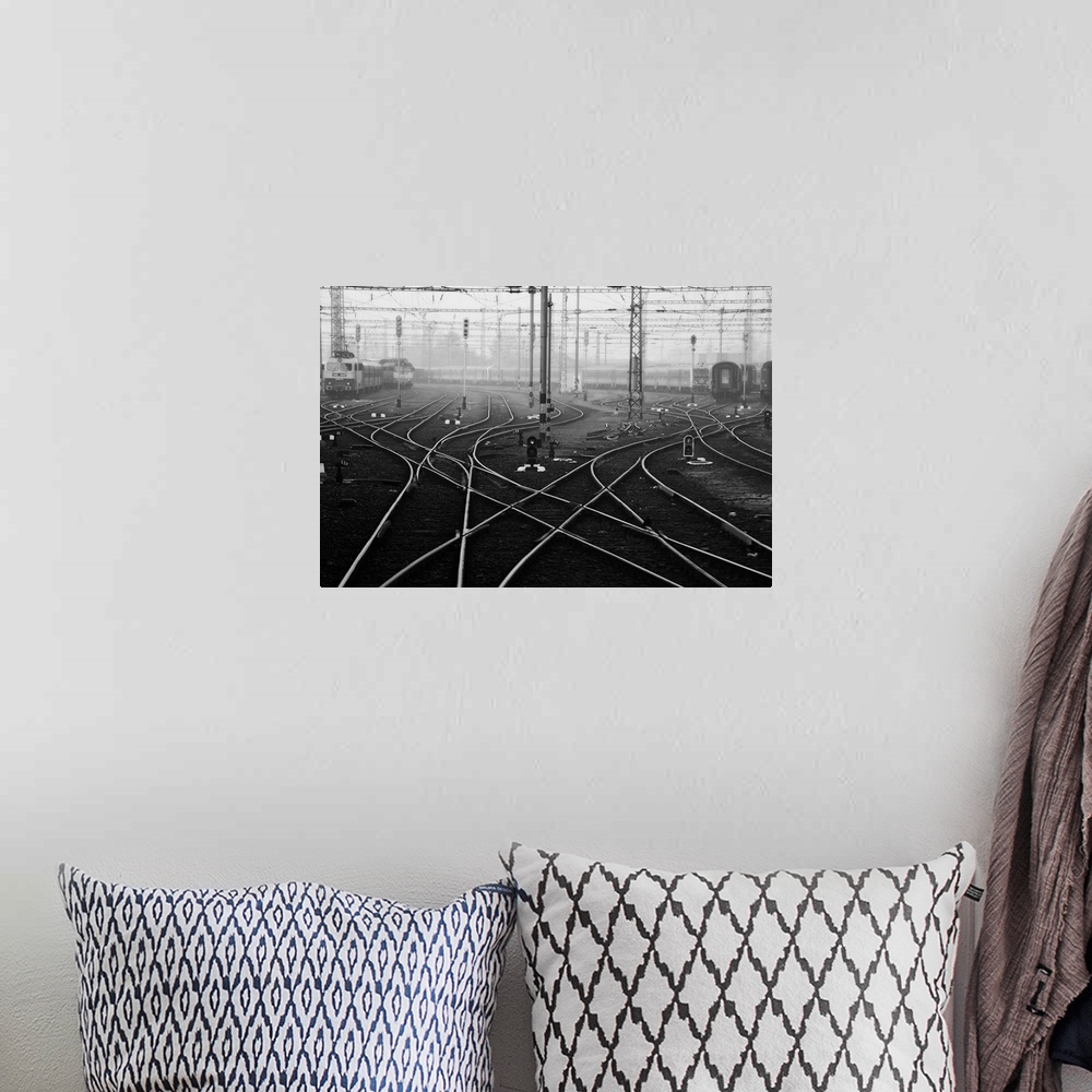 A bohemian room featuring Criss-crossing rail lines and wires at a train station in Budapest.