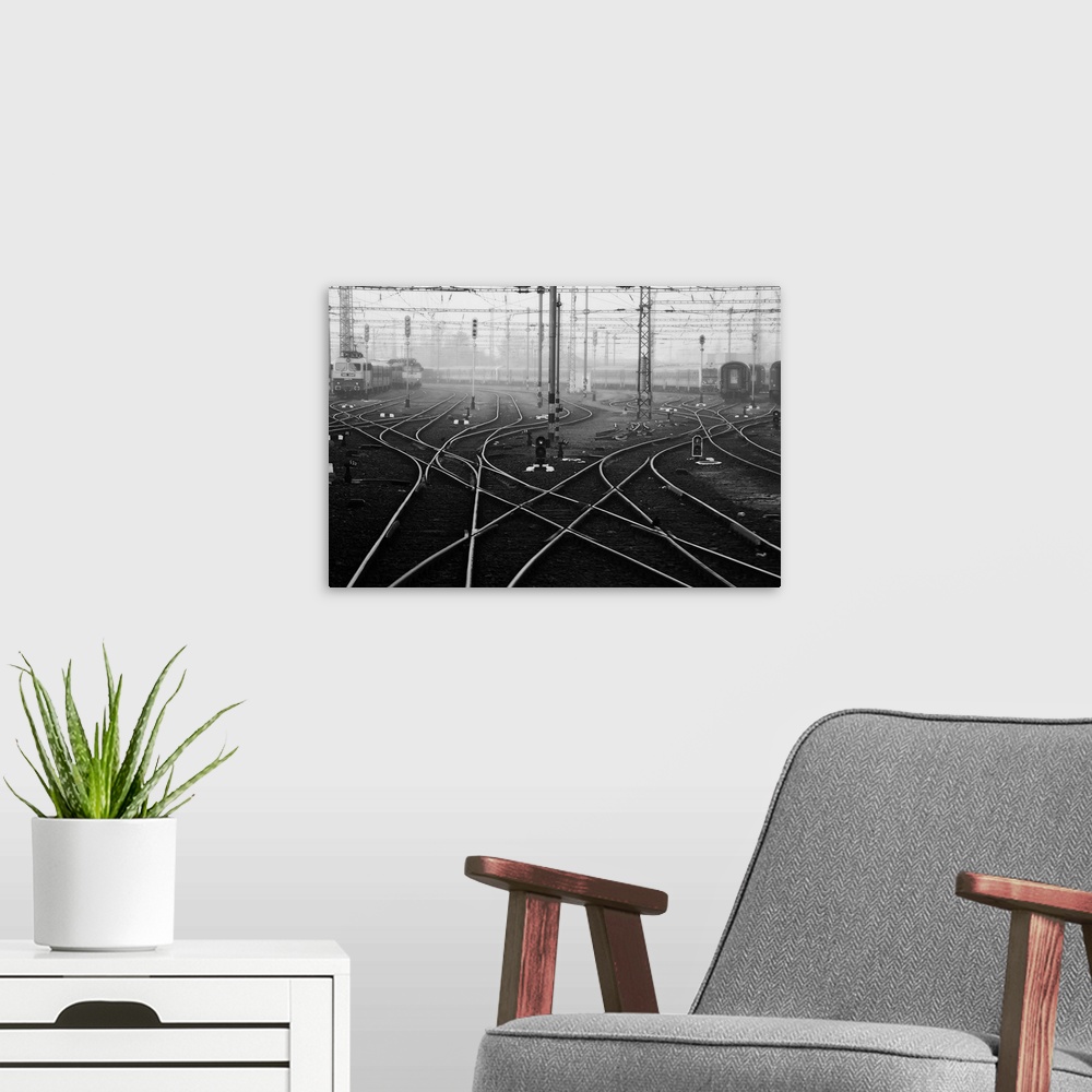 A modern room featuring Criss-crossing rail lines and wires at a train station in Budapest.
