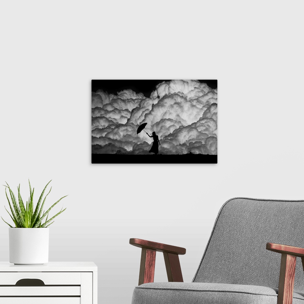 A modern room featuring Silhouette of a woman with an umbrella in front of huge storm clouds.