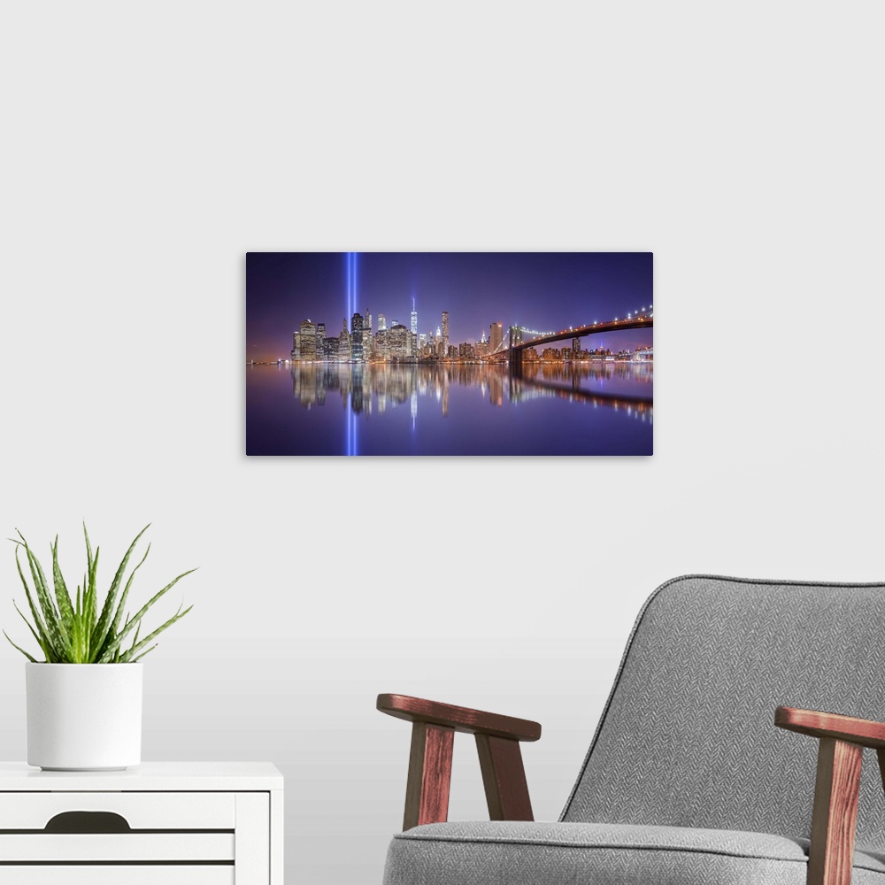 A modern room featuring A dynamic photograph of the NYC skyline with the Twin Towers memorial lights shining brightly.