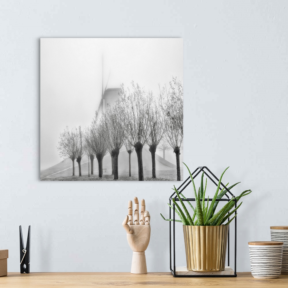 A bohemian room featuring A row of trees obscuring a windmill in the fog, Bruges, Belgium.