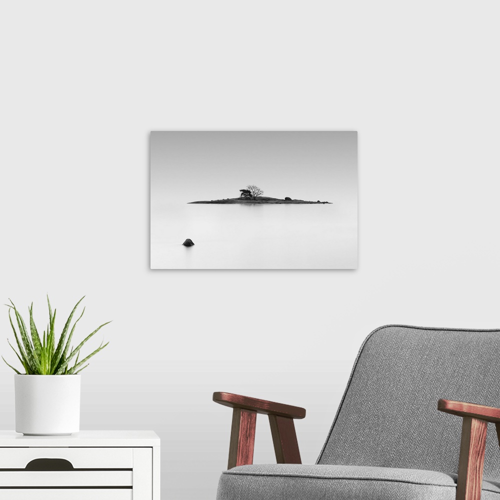 A modern room featuring Black and white photo of a small island in the middle of still water, Finland.