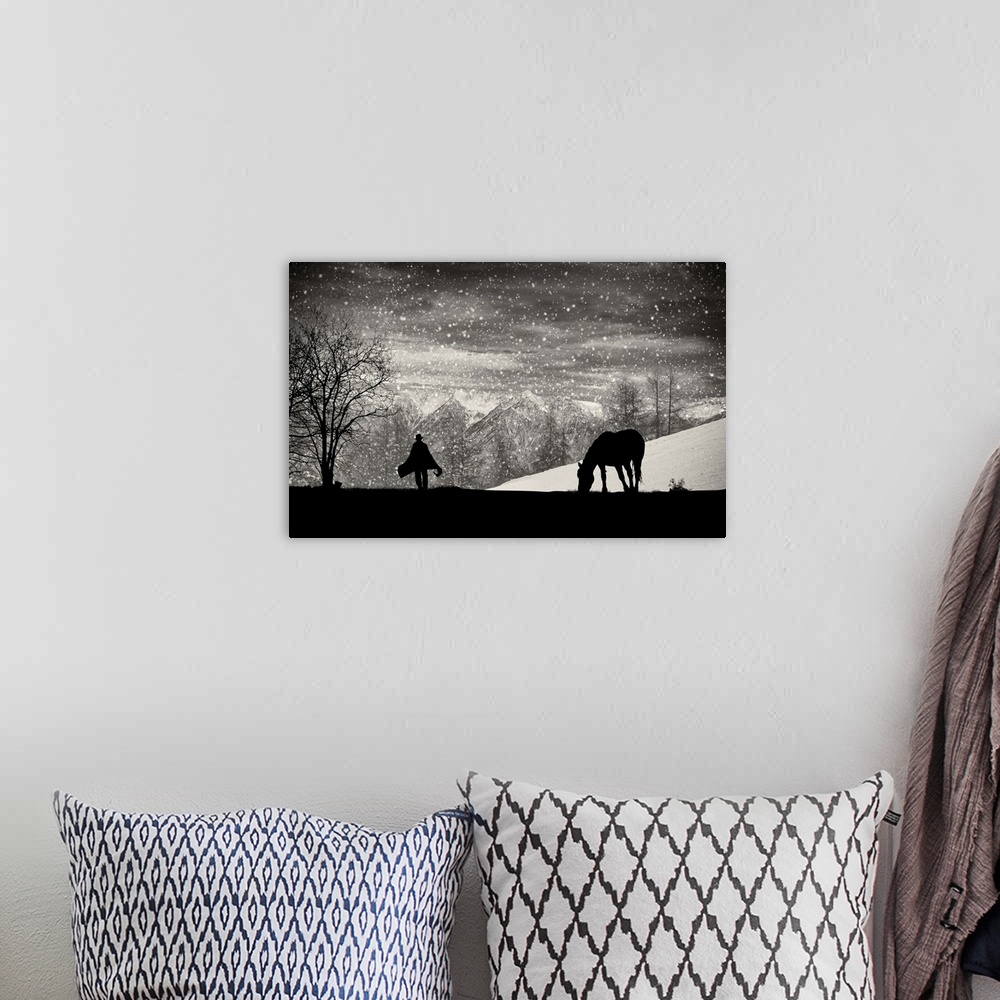A bohemian room featuring A silhouette of a grazing horse with a figure walking toward it in the falling snow.