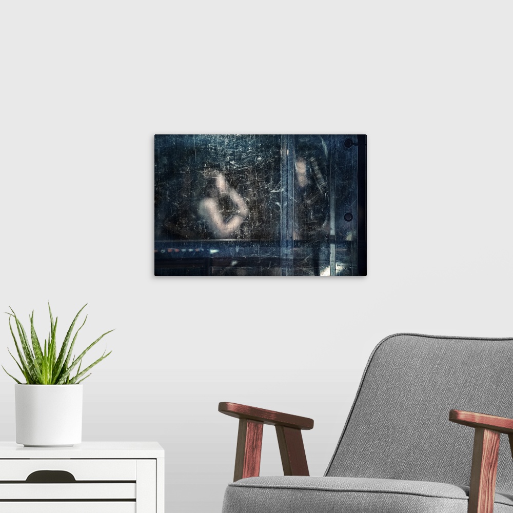 A modern room featuring An abstract photograph of a figure behind a blue dirty and scratched screen.
