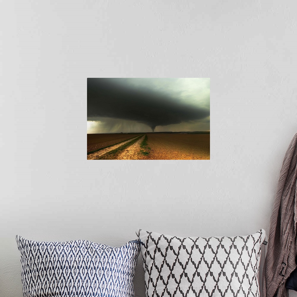 A bohemian room featuring A tornado extends into the horizon from storm-clouds overhead, seen from across farmland.