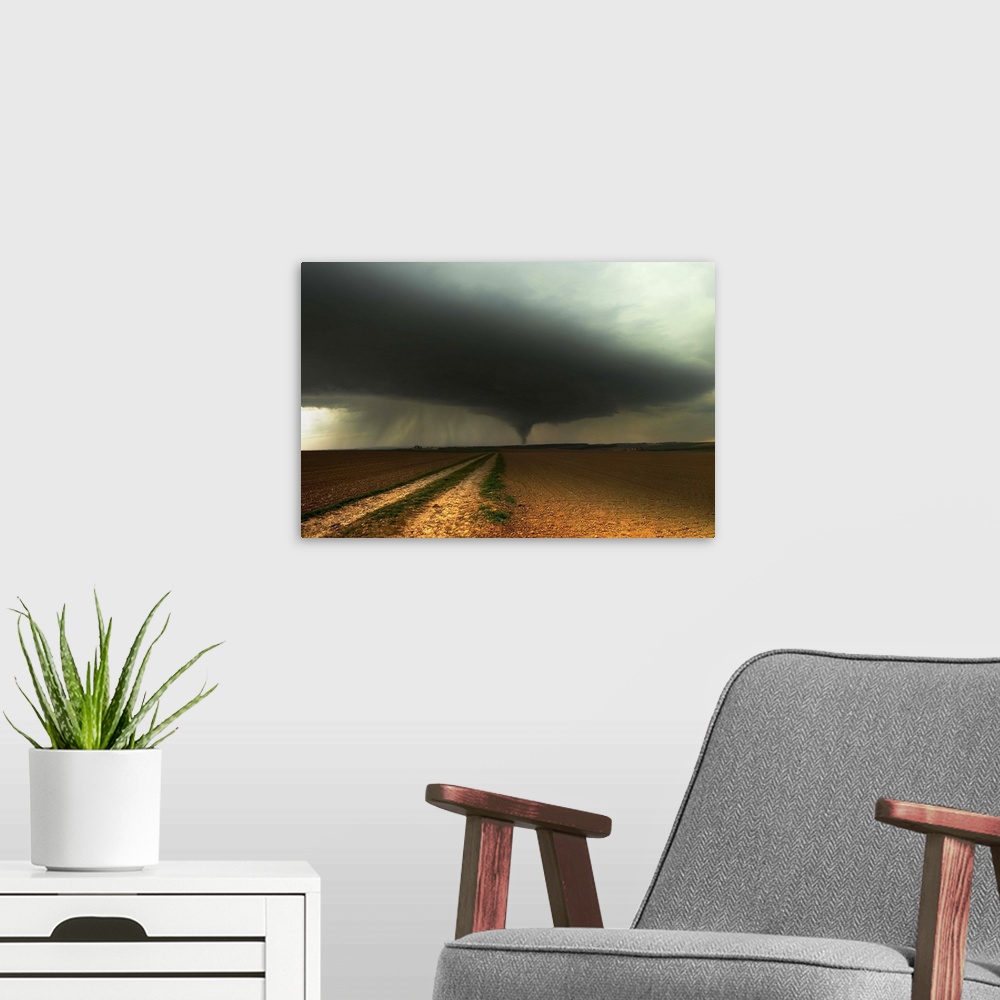 A modern room featuring A tornado extends into the horizon from storm-clouds overhead, seen from across farmland.