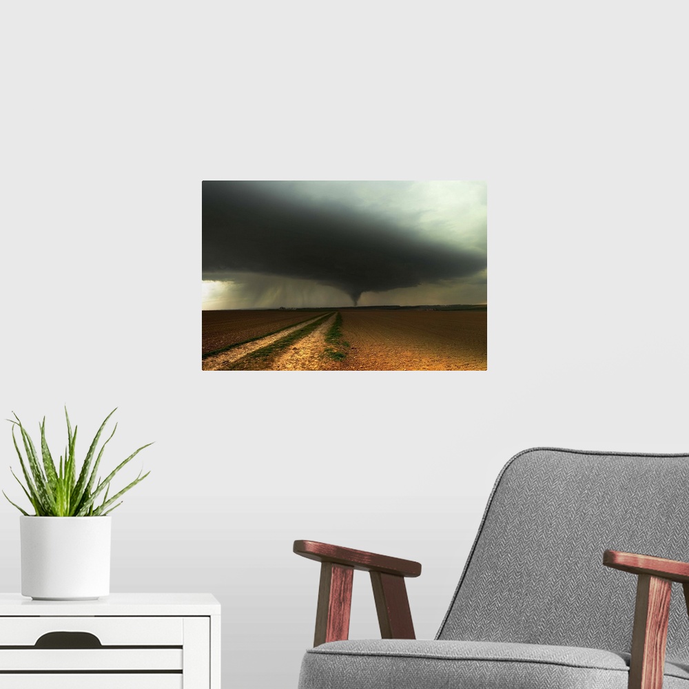 A modern room featuring A tornado extends into the horizon from storm-clouds overhead, seen from across farmland.