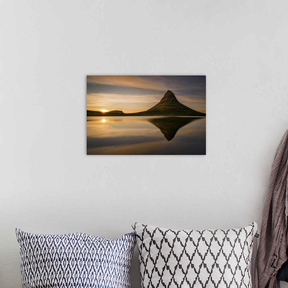 A bohemian room featuring Kirkjufell mountain at sunrise, reflected in the calm water below, Iceland.