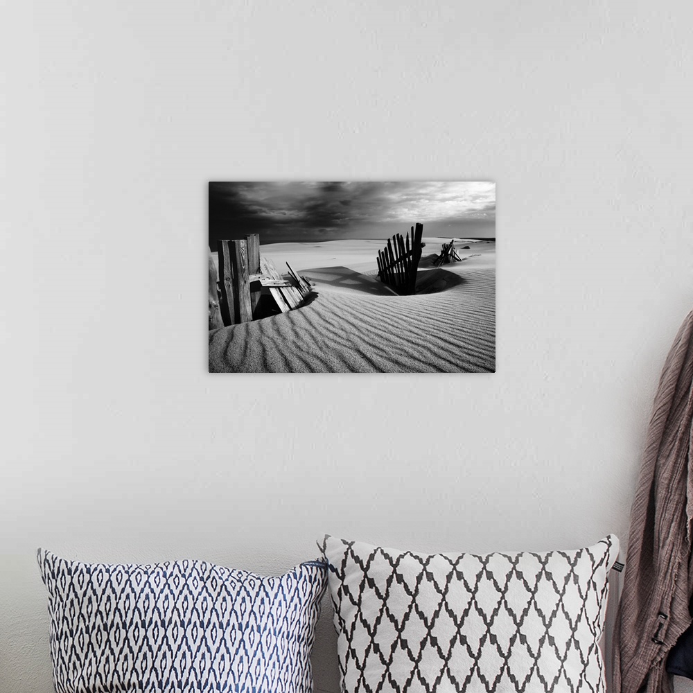 A bohemian room featuring Black and white photograph of a fence at the White Sands dunes in the Curonian Spit.
