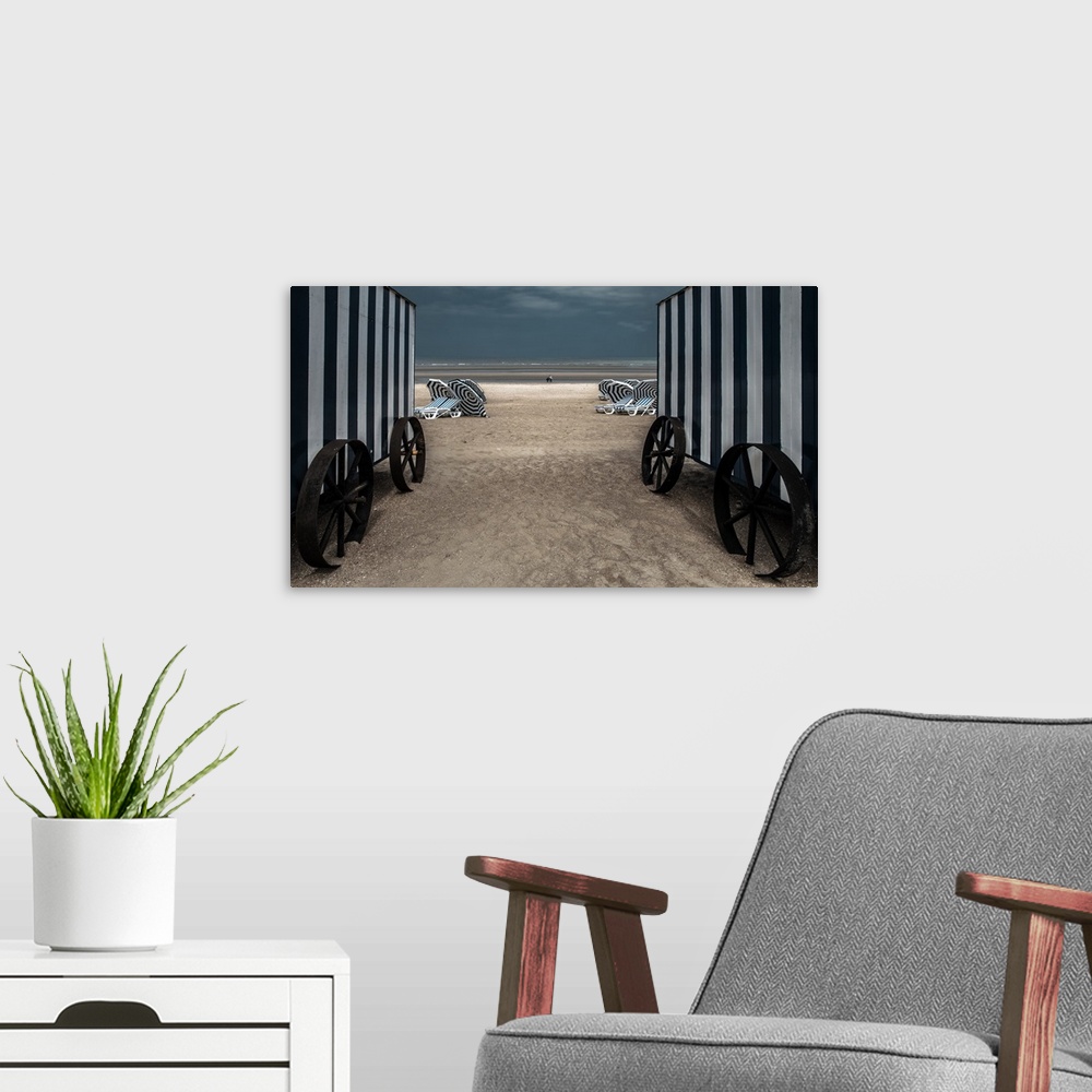 A modern room featuring Looking through two beach changing huts down to the beach.