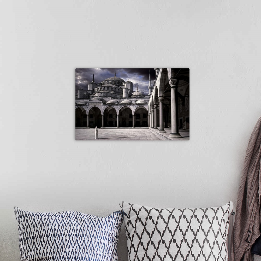 A bohemian room featuring A woman in the courtyard of the Blue Mosque in Istanbul.