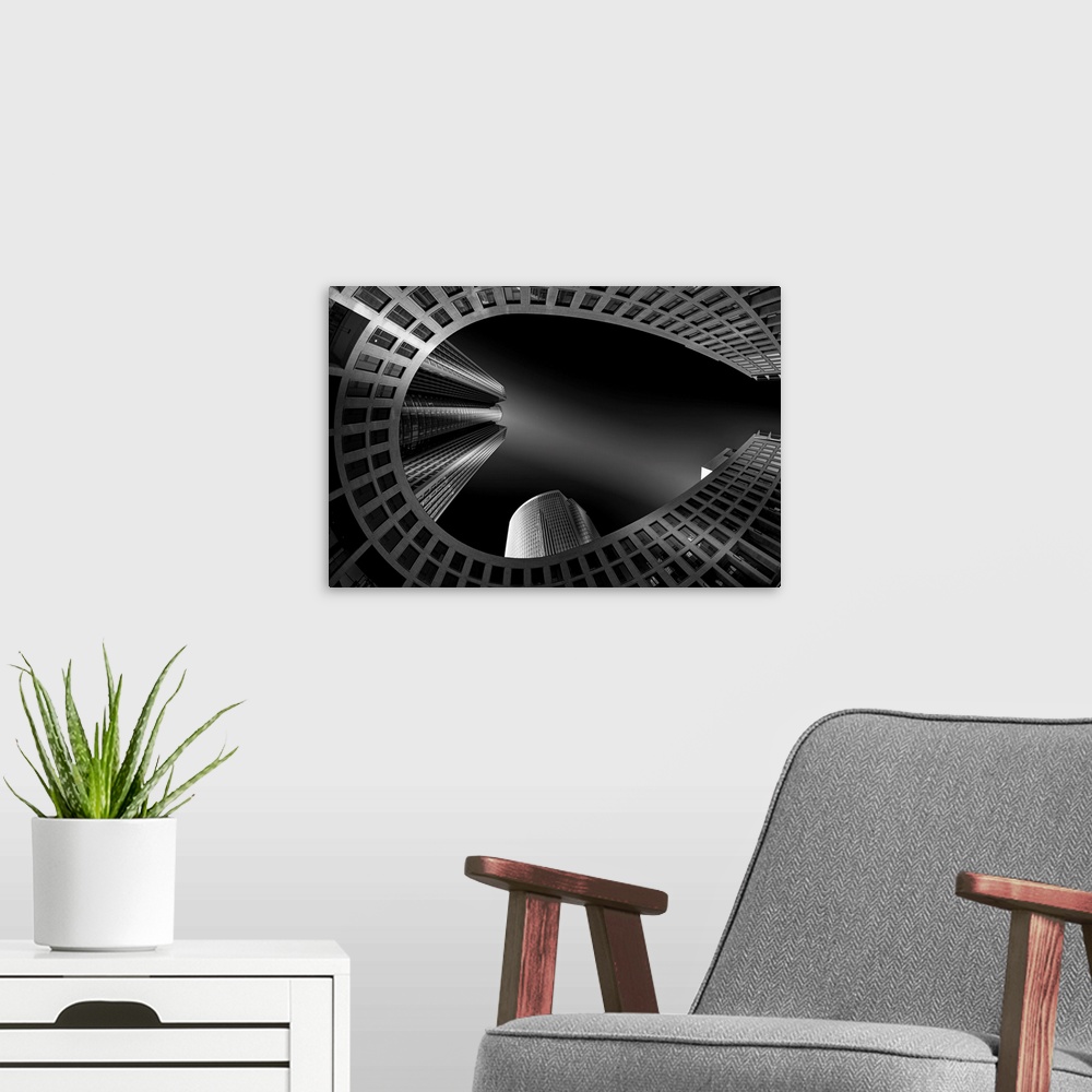 A modern room featuring Black and white architectural abstract photograph of a horseshoe building with other buildings sh...
