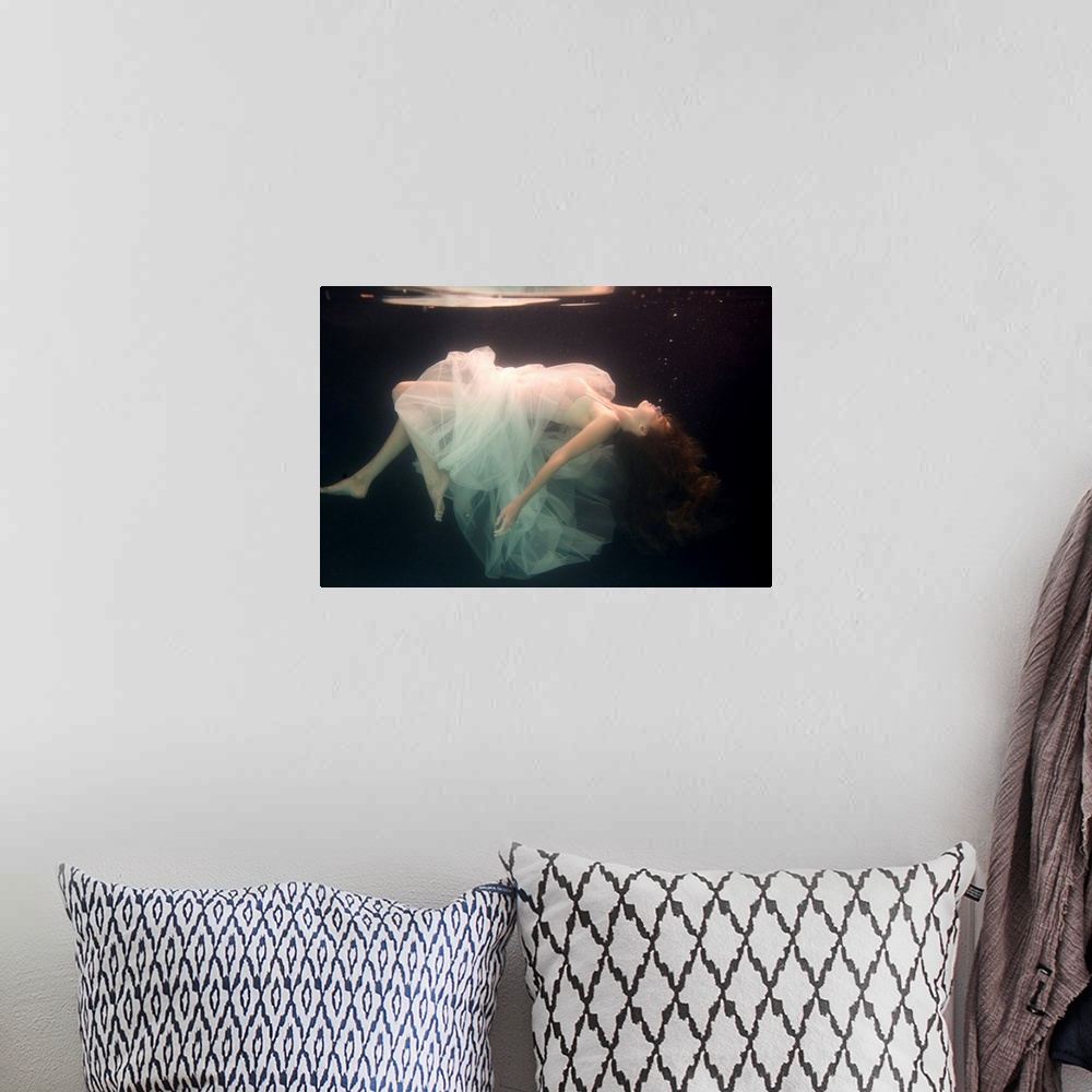 A bohemian room featuring A conceptual photograph of a woman in white dress suspended under water.