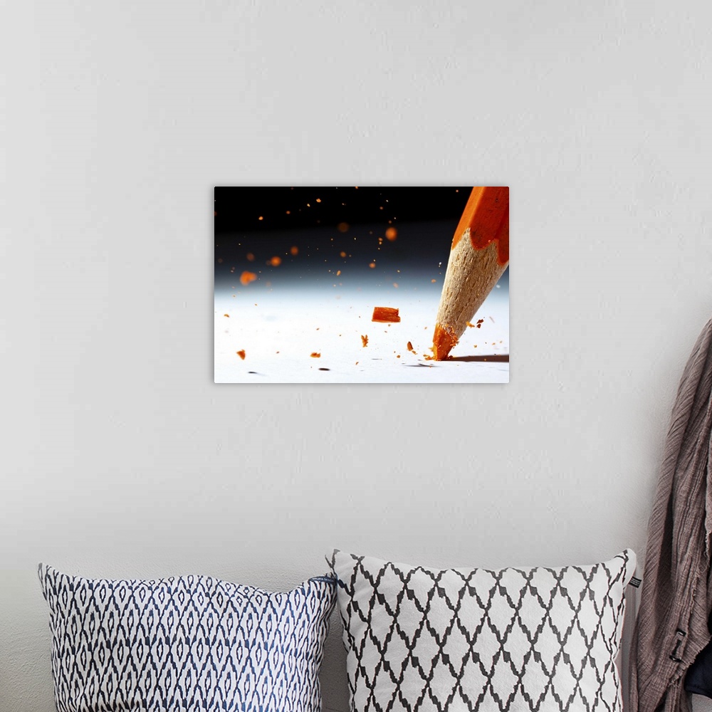 A bohemian room featuring Close up image of the lead of an orange colored pencil shattering.