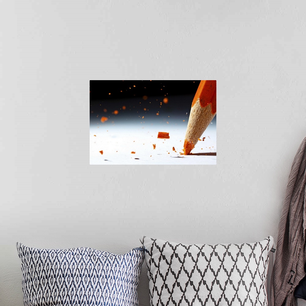 A bohemian room featuring Close up image of the lead of an orange colored pencil shattering.