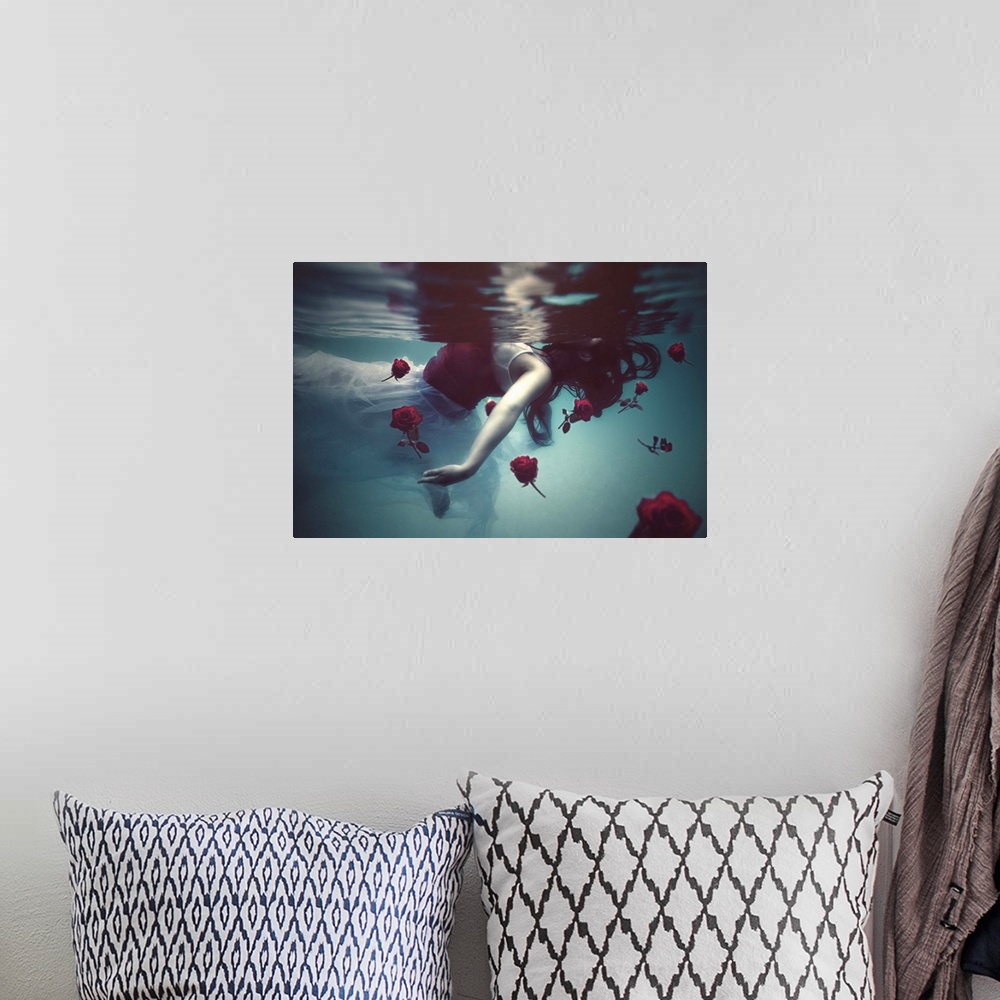 A bohemian room featuring A conceptual photograph of a woman in a white dress floating underwater with red roses.