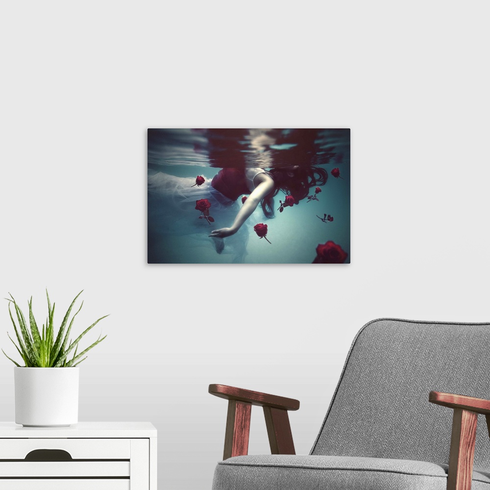 A modern room featuring A conceptual photograph of a woman in a white dress floating underwater with red roses.