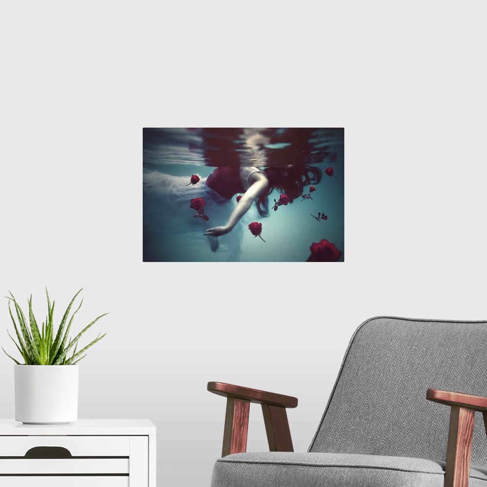 A modern room featuring A conceptual photograph of a woman in a white dress floating underwater with red roses.
