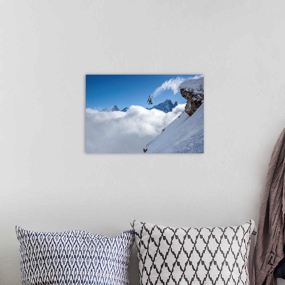 A bohemian room featuring A skier leaps off a mountain in France, kicking off snow from the ends of the skies.