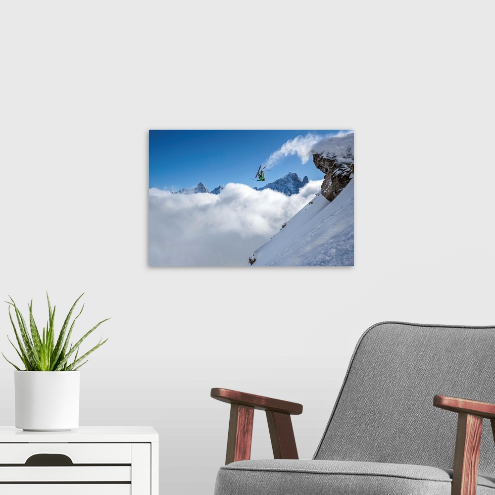 A modern room featuring A skier leaps off a mountain in France, kicking off snow from the ends of the skies.