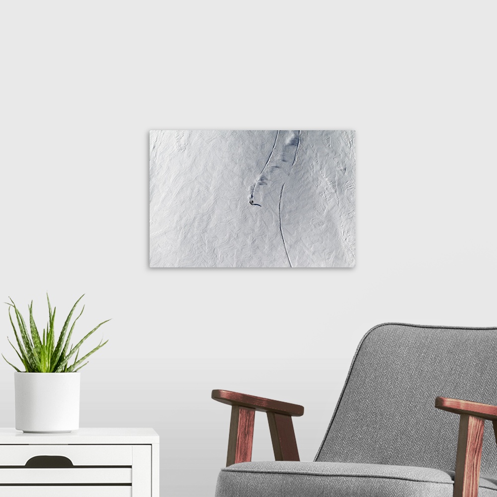 A modern room featuring Aerial view of a snowboarder cruising down a snowy mountain.
