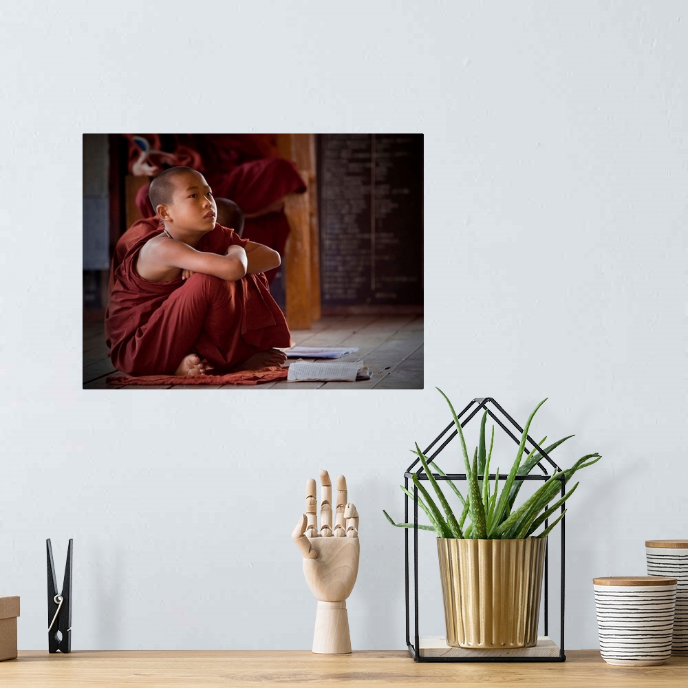 A bohemian room featuring A young monk in the Shwe Yangwe monastery, Myanmar.
