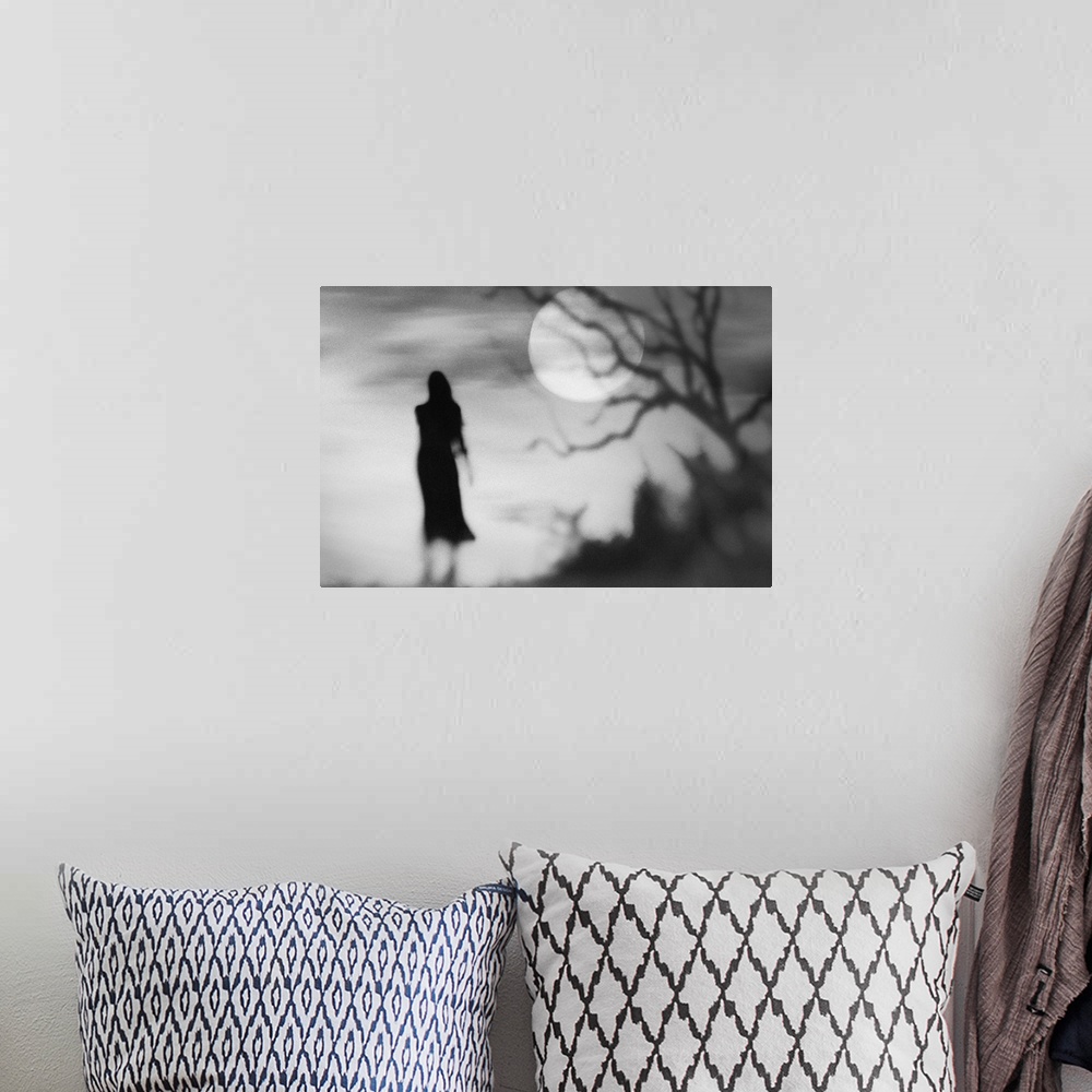 A bohemian room featuring Eerie conceptual photograph of a silhouetted woman against a background with a full moon.